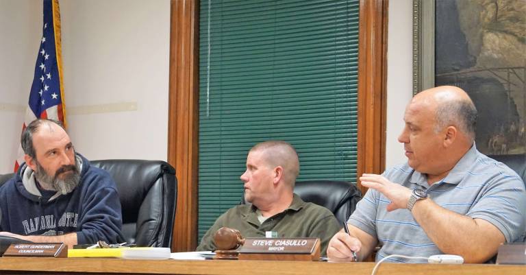 From left, Councilman Anthony Nasisi discusses underground storage tanks with Mayor Steve Ciasullo, far right. In center, Councilman Bub Gunderman listens to discussion.