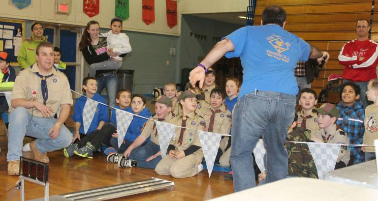 Cub scouts race pine wood derby cars Scout Leader Carlos Soares gets the scouts excited as the next race begins.