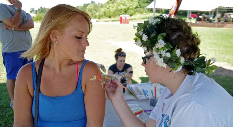 Hamburg business hosts wellness festival in Vernon Kara Kovach of Franklin paints a sun symbol on the upper arm of Kara Nelson of Stillwater.