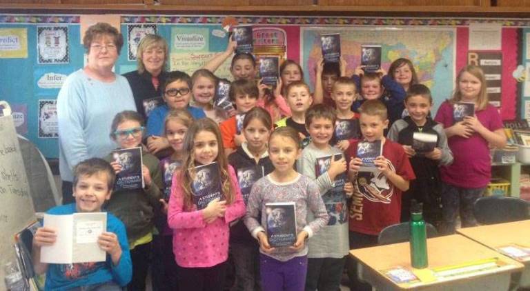 Rotarians present dictionaries to third graders