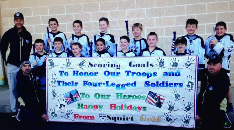 December: Supporting the Armed Forces - Twenty-five care packages were sent to Iraq and Korea. Pictured here are the Skylands Kings Squire Gold Hockey team: Back row, from left, &#x2013; Assistant Coach Joe Chromcik, Jonathan Chromcik, Jake Chromcik, Tyler Paluzzi, Rylan Gibbons, Sebastian Hamarcak, Michael Sadowski; Front row, from left &#x2013; Allen C. Magie, Anthony Prunty, Aiden Parlapiano, Kailin Kane, Henry Hogg, Jake Henningsen, Evan McHugh; Kneeling (Left to right) &#x2013; Assistant Coach Art Prunty and Head Coach Allen Magie.
