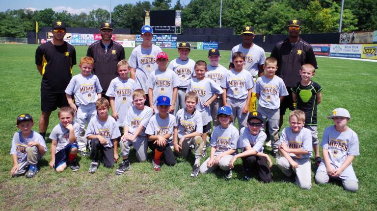 Back row from far left in black Sussex County Miners player Chris Chiaradio, assistant coach Alex Hernberger and far right manager Bobby Jones and assistant coach Carl Johnson with campers in a portrait.
