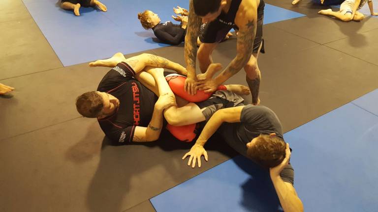 Coach Mike Pagano adjusts the technique of Ray Carroll (left) as he drills a technique on his partner Justin Zinn (right).