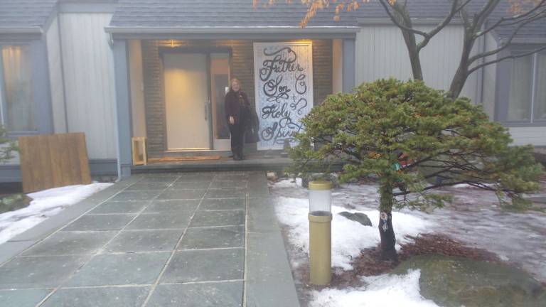 Local church to hold four-day celebration of assault rifles Sean Moon’s secretary, Lordes Swarts, stands at the entry to Moon’s home (Photo by Frances Ruth Harris)