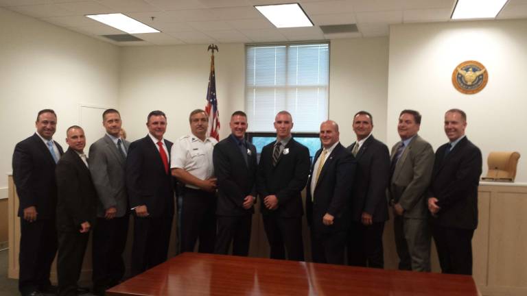 Hamburg Sgt. Christopher Nichols, sixth from left, is shown after being sworn into his new position at the Maywood Police Dept. He will resign from Hamburg effective July 1.