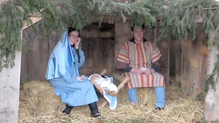 Our Lady of Fatima parishioners tell the story of Christmas The Vitulli family — Chiara, James and baby James — portray the Holy Family of Mary, Joseph and baby Jesus (Photo by Janet Redyke)