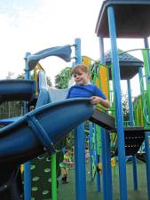 Aidan Heninger-Lowell, 7, goes down the slide at the new completely inclusive playground at C.O. Johnson Park in Byram. (Photo by Theresa Esposito)