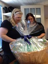 Cindi Auberger puts together one of the many baskets that will be auctioned at the November 5 Beefsteak Dinner by the Vernon Township Historical Society while society trustee Doreen Edwards looks on. Tickets are still available. A limited number of tickets will be sold at the door.