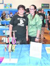 Logan Henderson and Danielle Frederick stand behind the Logs Bracelets table.