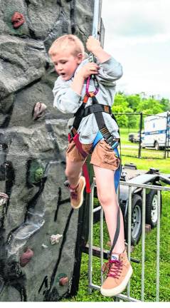 <b>Cooper Gerbauer climbs the rock wall.</b>