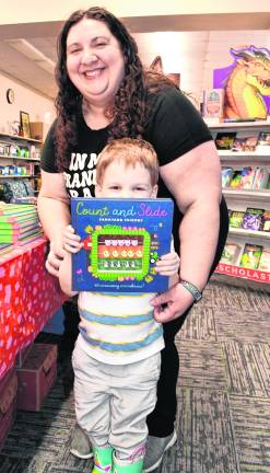 Degan Harvey shows what he picked as his mother, Melissa, stands behind him.