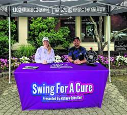 Rachel Mastrangelo and Matthew Magura, the fouder of Swing For a Cure, sit at a table.