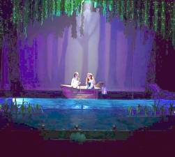 Ariel sits in a boat with Prince Eric, hoping to be kissed.
