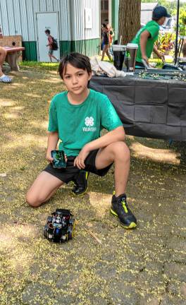 <b>Ian Kamphaugen with a robot that he built Saturday, Aug. 2. (Photo by Nancy Madacsi)</b>