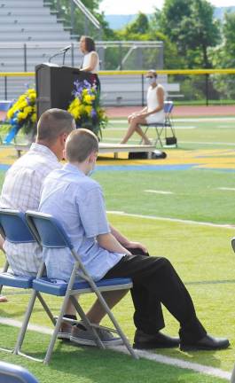 A father and son listen to Principal Rosemary Gebhardt's Advancement Address. (Photo by Vera Olinski)