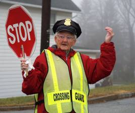 PHOTOS BY VERA OLINSKI Crossing Guard Dot Kays waives cars through the Hamburg School intersection one last time.