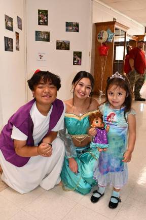 Margoth Tello poses with characters from Aladdin.