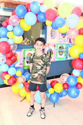 Steel Kent stands in front of balloons.