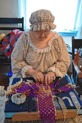 <b>DAR member Clara Eastby makes a scarf of bobbin lace.</b>