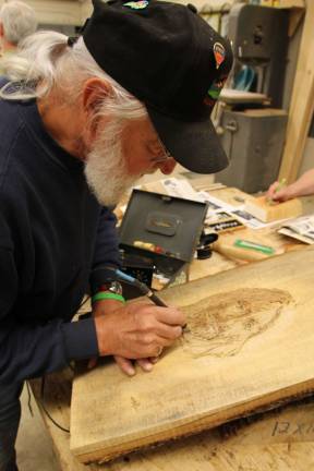Henry Hanzo demonstrates his woodburning technique.