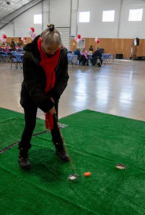 Bonnie Schulz takes part in the putting contest.