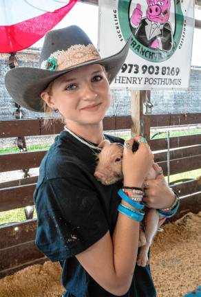 <b>Eleanor Posthumos holds a baby pig Saturday, Aug. 2. (Photo by Nancy Madacsi)</b>