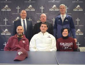 Pope John XXIII Regional High School senior offensive lineman Giovanni Potente, seated in center, poses for a picture after he signed his National Letter of Intent to continue his academic and football careers at Fordham University on Wednesday at Pope John XXIII Regional High School in Sparta. Seated next to Potente, from left, are his father, Giuliano, and his mother Janis. Standing in back are Pope John Principal Gene Emering, Pope John President Rev. Msgr. Kieran McHugh, and Pope John head coach Brian Carlson. (Photos provided).