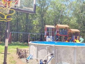 A large swingset is shown behind a basketball hoop and a pool in Jeremy Curcio's property in Hardyston Township.