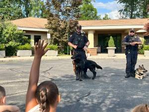 Officers from the Sussex County Sheriff’s Department give a K-9 demonstration to children at Project Self-Sufficiency’s Back-to-School Fair. (Photo provided)