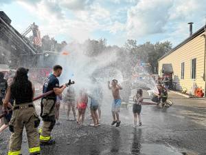 Children play in the water during a wetdown of the new ladder truck Saturday, Aug. 16 at Jefferson Township Fire Department Company 1. (Photos by Denise von Wilke)