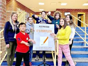 The poster design team from left to right: Kasey Kervatt (teacher), Ethan Barnett, Christopher Delcalzo, Samuel Tobachnick, Juste Survila, Gabrielle Rubalcava, and Raquel Spooner (teacher).