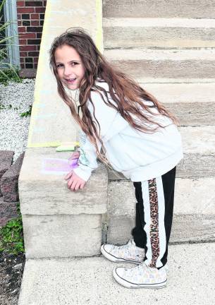 Leila Baez poses near the area by the front steps she decorated.