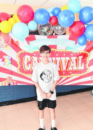Giovanni Pagan poses in front of a sign.