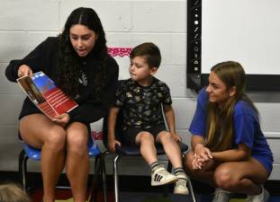 BK1 Juniors Sydney Vierzchalek, left, and Emily Pauciello read to preschool student Rory Coombs. (Photos provided)