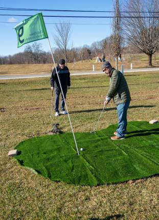 Darren Rist putts on the makeshift course. Four nine-hole, par-three courses were set up at the Sussex County fairgrounds.