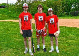 DA1 Connor Prout, Joe Elko and Brady Conklin, all of Sussex, wear T-shirts with a photo of Dolson ‘Doc’ Ayers Sr. at the first Doc Ayers Charity Game on Sunday, May 19 at High Point Regional High School. The money raised will go to a scholarship in memory of Ayers, who helped coach the school’s baseball team for 24 years. (Photos by Maria Kovic)
