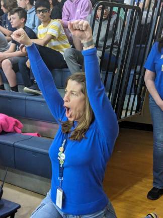 Teacher Tammy Peek cheers during the game.