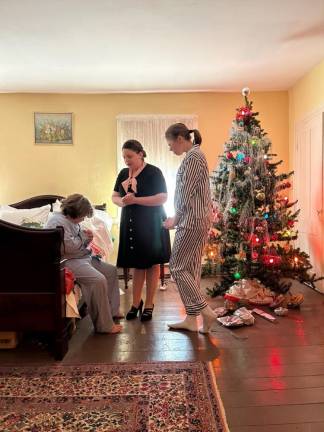 In an upstairs room representing Christmas Eve 1944, August Ziccardi, Pastor Katherine Scott-Kirschner and Harmony Swansson portray Wally Fielden and her two children, Ruth and Jack.