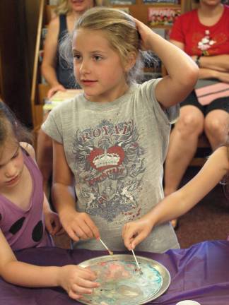 Sarah Coscia, 8, of Hardyston after observing spots of food coloring in a pan of milk react to liquid soap.