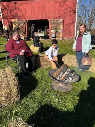 Heather Fernandes, Eric Fernandes and Julie Jordan-Scott by the outdoor fire.
