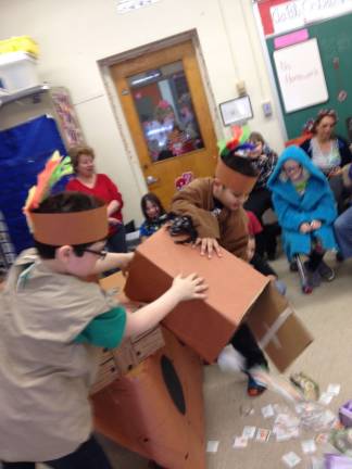 James Henry and Ethen Compton simulate pouring tea into the harbor in a re-enactment of the Boston Tea Party