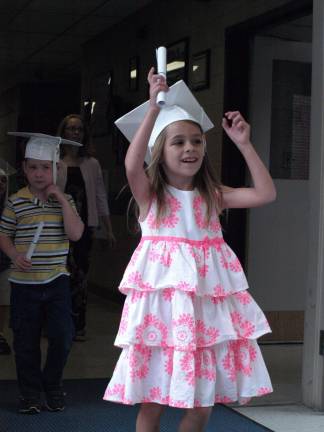 Proud graduate Ashley Sutherland and her fellow kindergarten graduates leave with their diplomas.