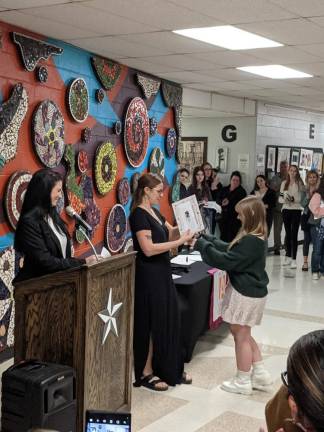 Director of Curriculum Taryn Geuther and Art teacher Amy Fairweather present Emily O’Brien with her certificate and medal.