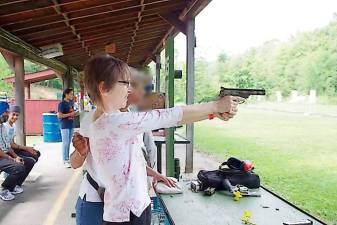 Anita Collins of Hamburg with a handgun instructor during a past Family Day at Cherry Ridge Range (Photo by Chris Wyman)
