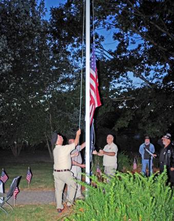 The flags are shown being raised above the Northwest New Jersey Vietnam Veterans Memorial.