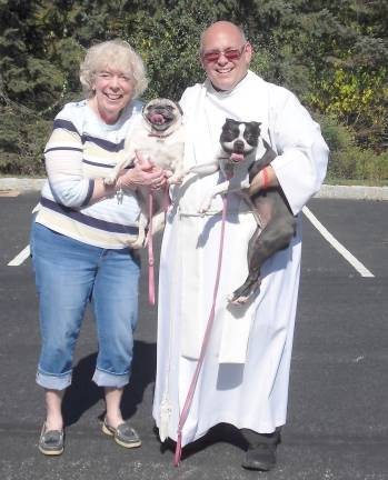 Christine Benson is shown with Molly (boston terrier and Maggie (pug) and Rev, Michael Rodak.