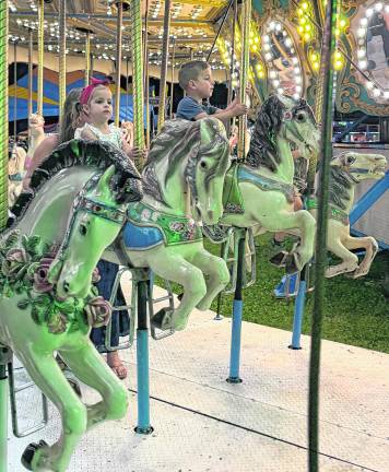 <b>Children ride the carousel.</b>