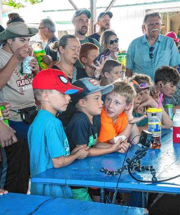 <b>Fair-goers watch battling robots Saturday, Aug. 2. (Photo by Nancy Madacsi)</b>.
