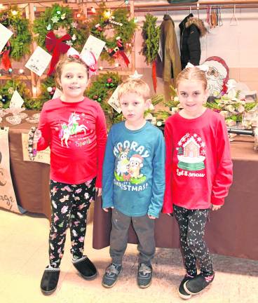 Adelaide Potanka and Parker and Savi Franek, all of Lafayette, stand in front of a table.