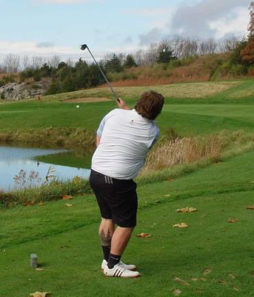 Owen Pullis from Team Minerals hits his one handed tee shot which came to rest 7 feet 9 inches from the cup to win the prize